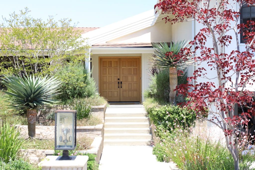front of a home with trees and shrubs planted
